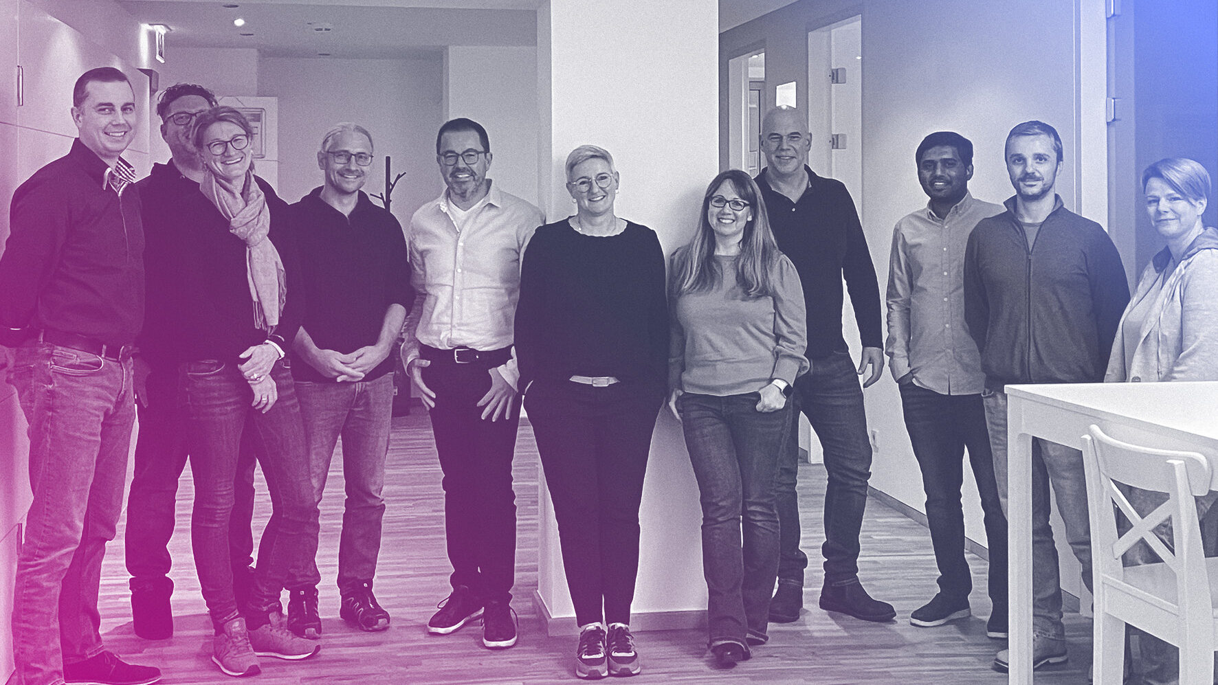 Mehrere Menschen stehen als Gruppe im Büro